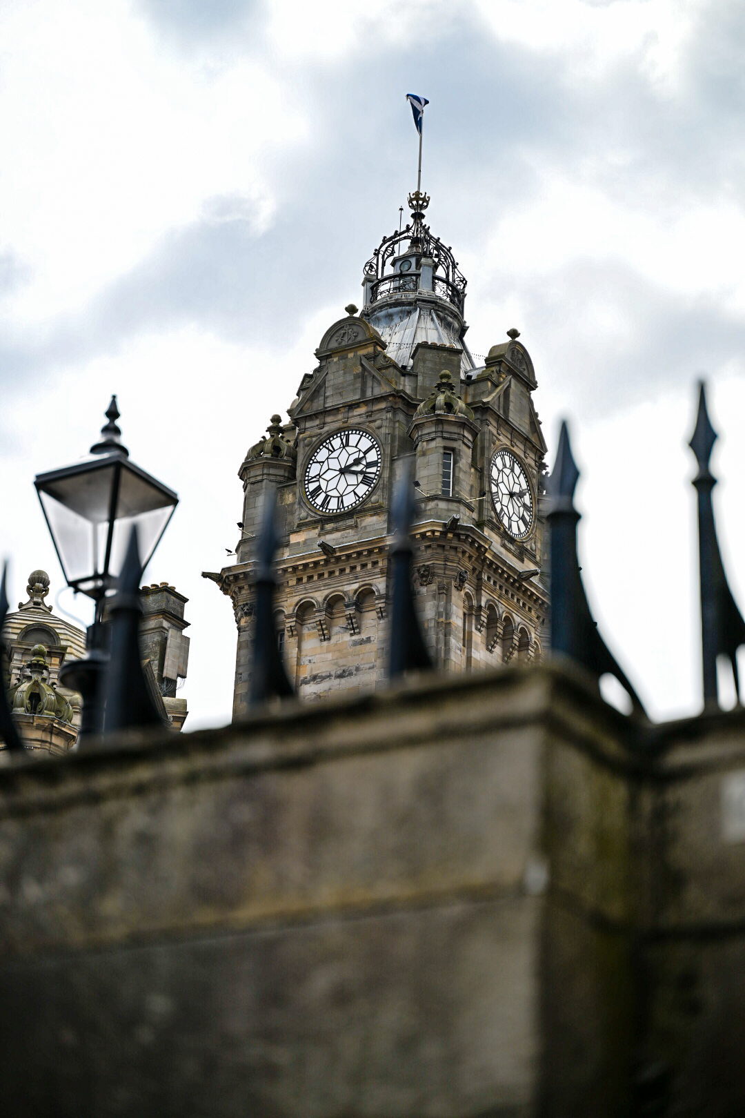 Edinburgh clock tower framed by iron railings