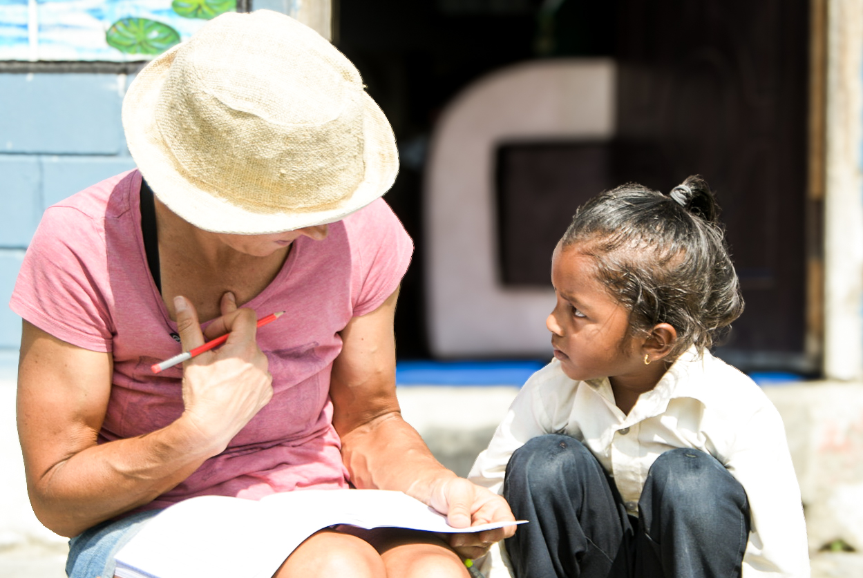 Woman in a sun hat talking with a young girl on a doorstep