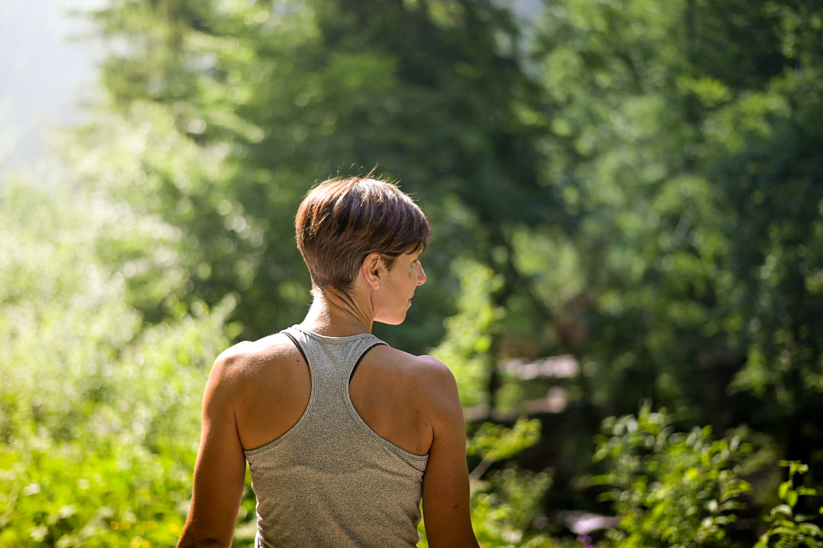 Athlete looking back over her shoulder in dappled forest light