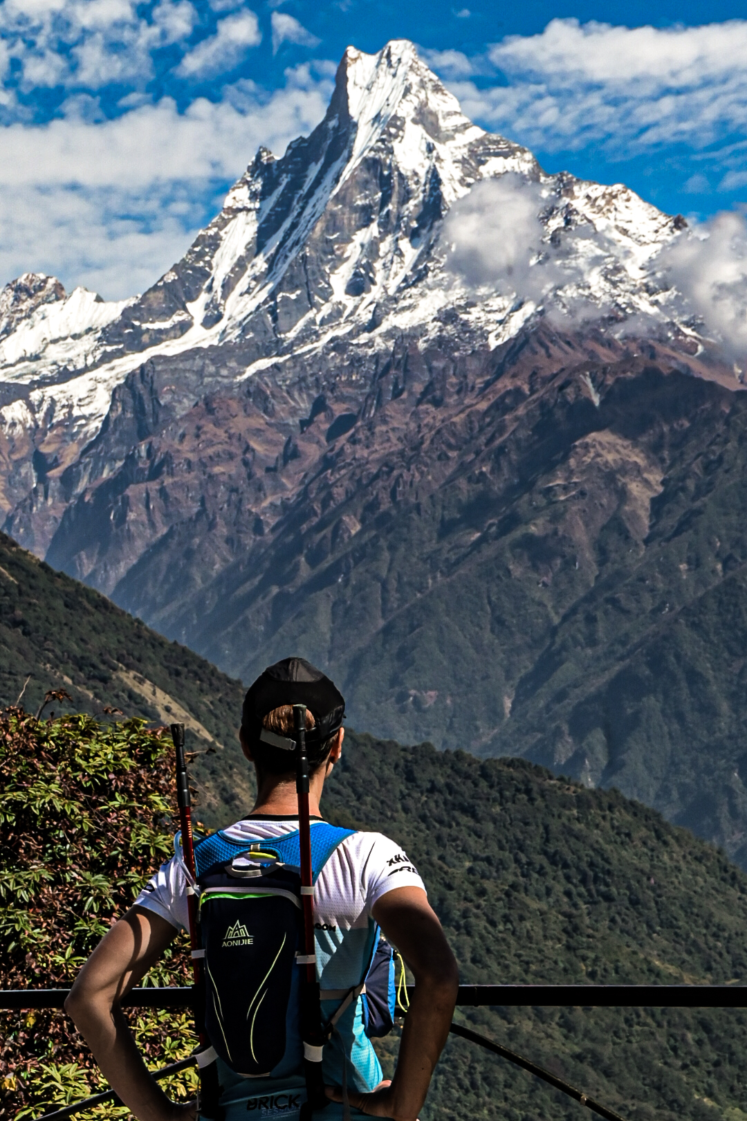 Runner pausing to look up at the snow capped peak of Machapuchare