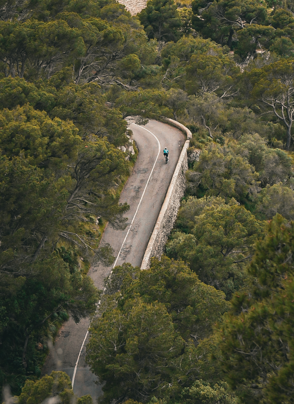 Lone rider on a winding mountain road seen from above