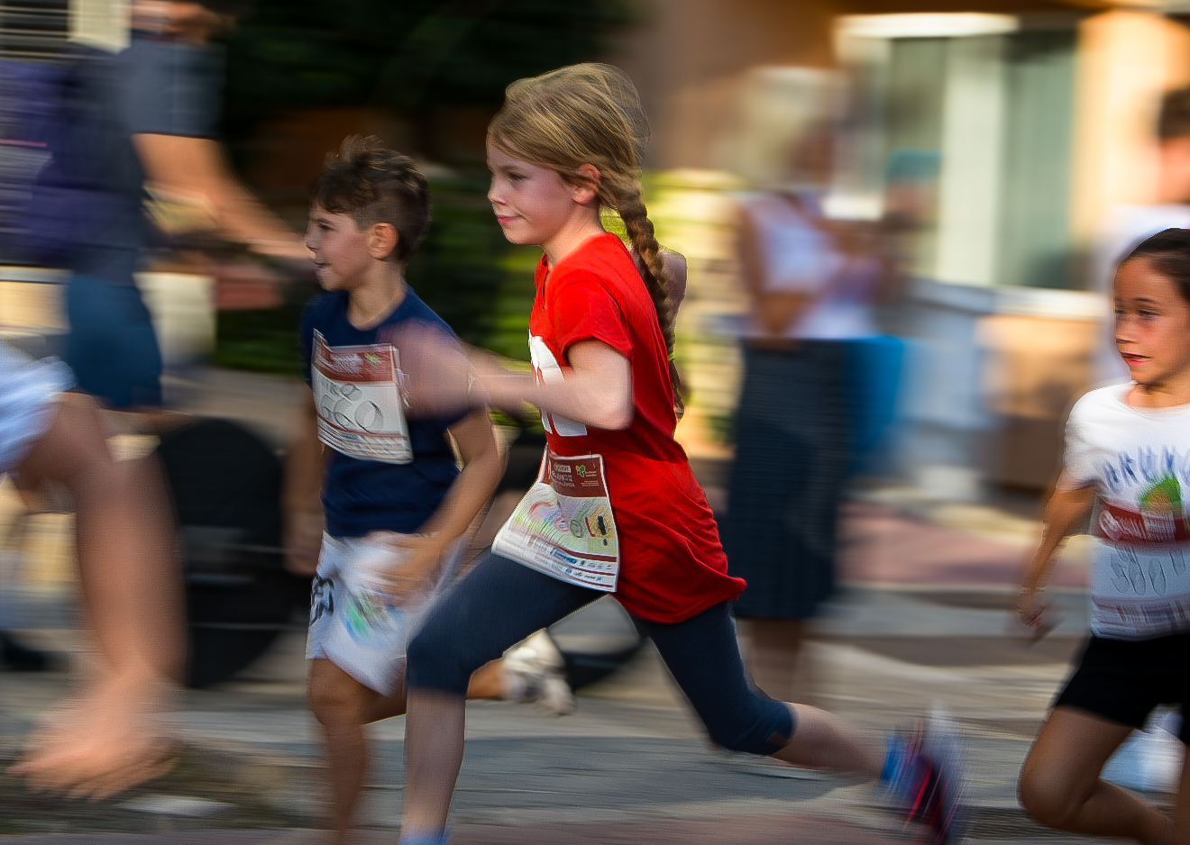 Panned shot of children sprinting in a street fun run