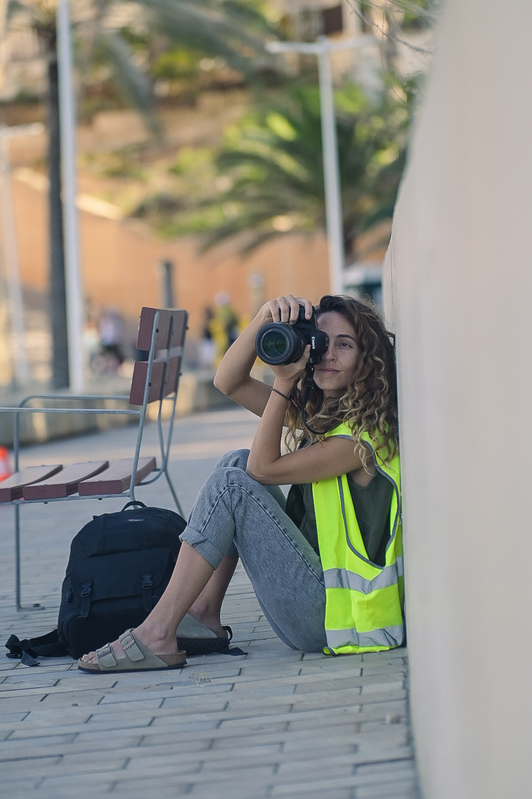Race photographer sitting against a wall shooting along the course